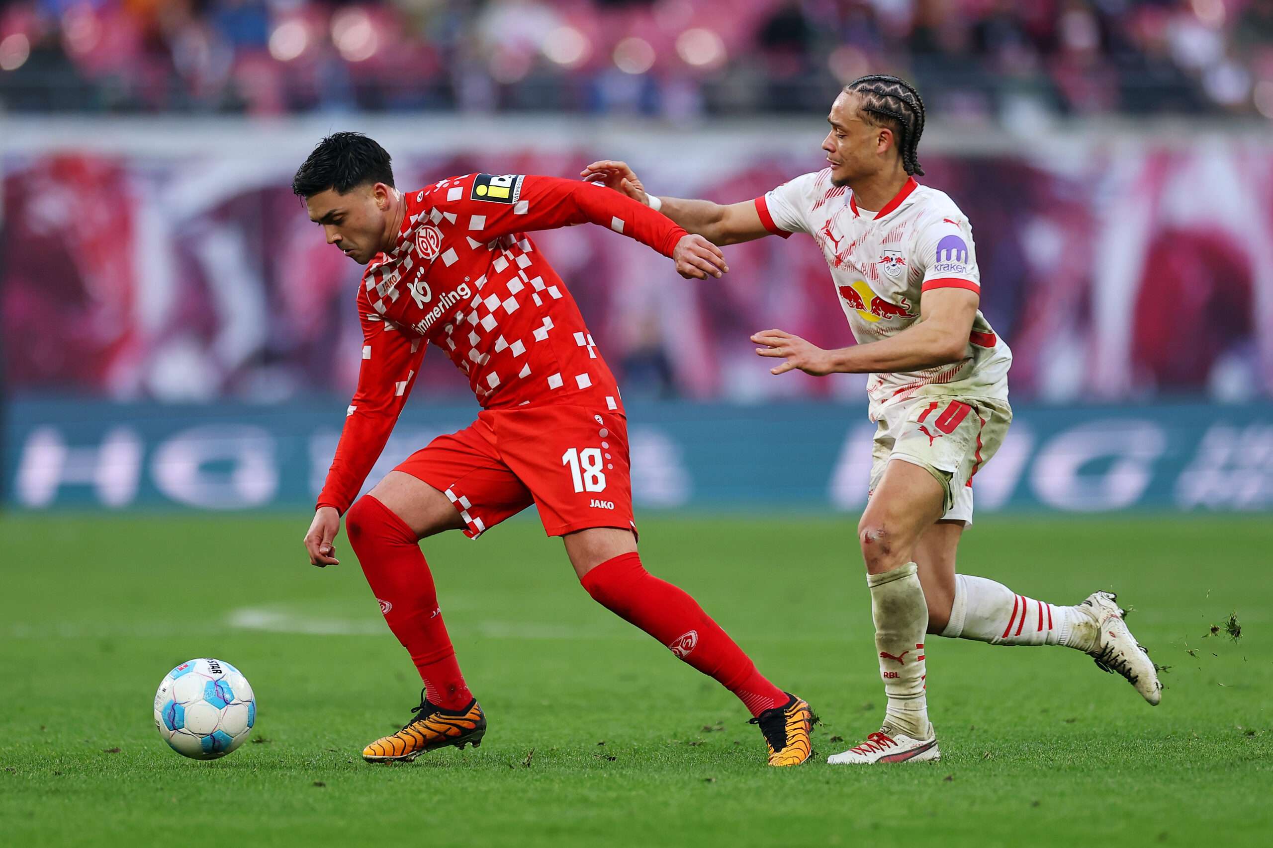 LEIPZIG, GERMANY - MARCH 01: Nadiem Amiri of 1.FSV Mainz 05 is challenged by Xavi Simons of RB Leipzig during the Bundesliga match between RB Leipzig and 1. FSV Mainz 05 at Red Bull Arena on March 01, 2025 in Leipzig, Germany. (Photo by Maja Hitij/Getty Images)